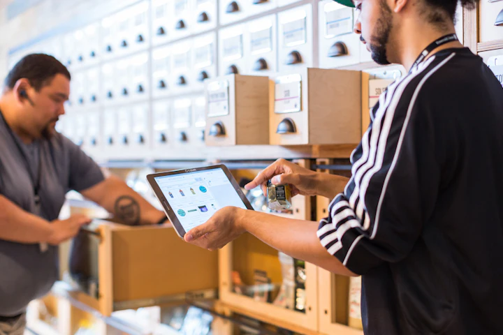 Two colleagues checking stock on a tablet in a shop